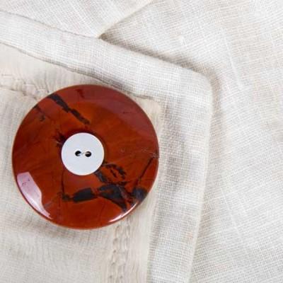 Jaspis Rouwknoop met een knoopje van een dierbare wordt gedragen als broche op een zomerjasje.