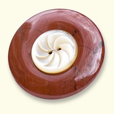 Een jaspis Rouwknoop met een knoop van een jas van een dierbare erop. De rode jaspis is vaak geaderd.