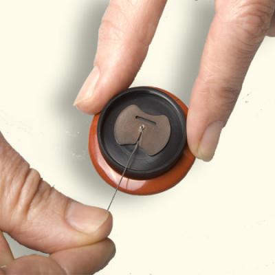 Het knoopje kan je zelf eenvoudig verwisselen. Bijna elk knoopje past op de Rouwknoop. Het knoopje vastzetten met een sterke draad.