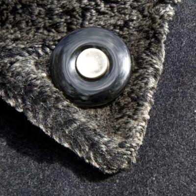 Onyx Rouwknoop met een knoopje van een dierbare wordt gedragen als reversspeld op een winterjas.