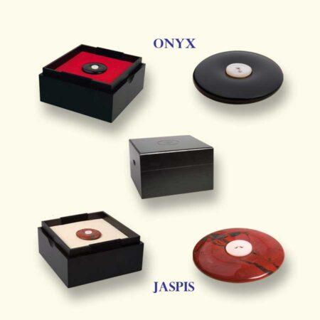 Zwarte onyx en steenrode jaspis Rouwknoop. Standaard voorzien van een parelmoeren knoopje om te verwisselen. In het midden het bewaarkistje.