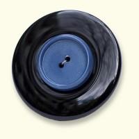 Een onyx Rouwknoop met een jasknoop van een dierbare erop. De zwarte onyx is altijd egaal van kleur.