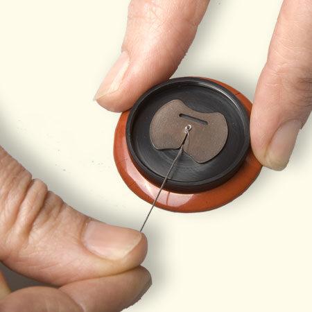 Het knoopje kan je zelf eenvoudig verwisselen. Bijna elk knoopje past op de Rouwknoop. Het knoopje vastzetten met een sterke draad.