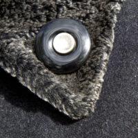 Onyx Rouwknoop met een knoopje van een dierbare wordt gedragen als reversspeld op een winterjas.
