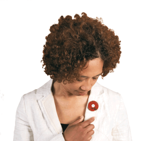 De Rouwknoop kun je dragen als hanger, reversspeld en broche. Hier draagt een jonge vrouw een jaspis Rouwknoop als broche op haar jasje.