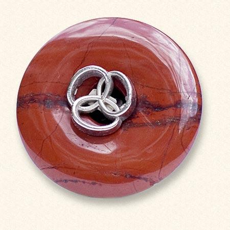 Een jaspis Rouwknoop met een metalen knoopje van een dierbare erop. De rode jaspis is vaak geaderd.