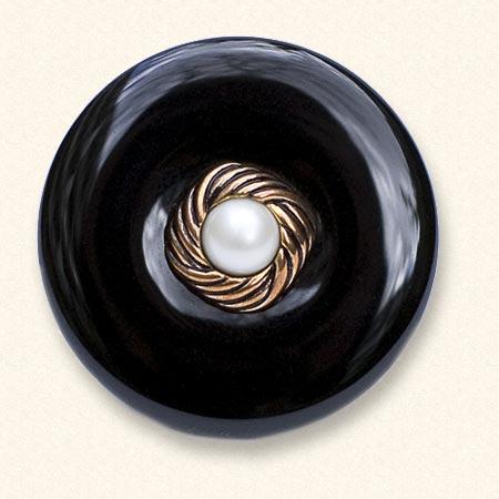 Een onyx Rouwknoop met een jasknoop van een dierbare erop. De zwarte onyx is altijd egaal van kleur.