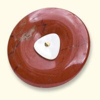 Een jaspis Rouwknoop met een knoopje van een dierbare erop. De rode jaspis is vaak geaderd.