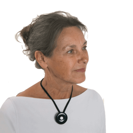 Vrouw draagt een onyx rouwknoop met een knoopje van haar dierbare als hanger. De Rouwknoop kun je ook dragen als broche of reversspeld.